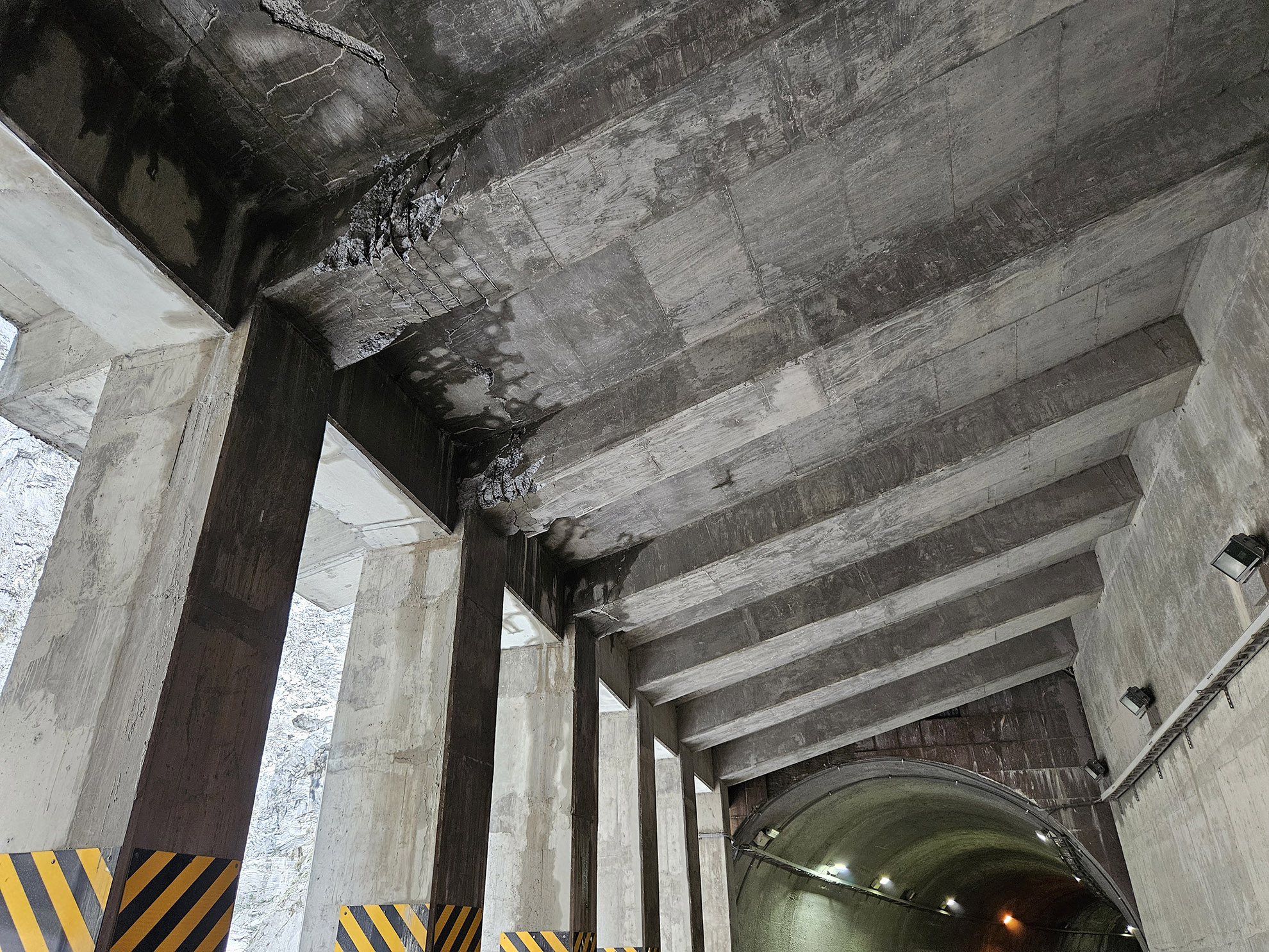 impact de blocs lors du séisme, la couverture de protection sur la partie aval été très faible, elle n'a pu joué son rôle de dissipateur d'énergie et de ce fait présence de fissuration des dalles et rupture par cisaillement des poutres.